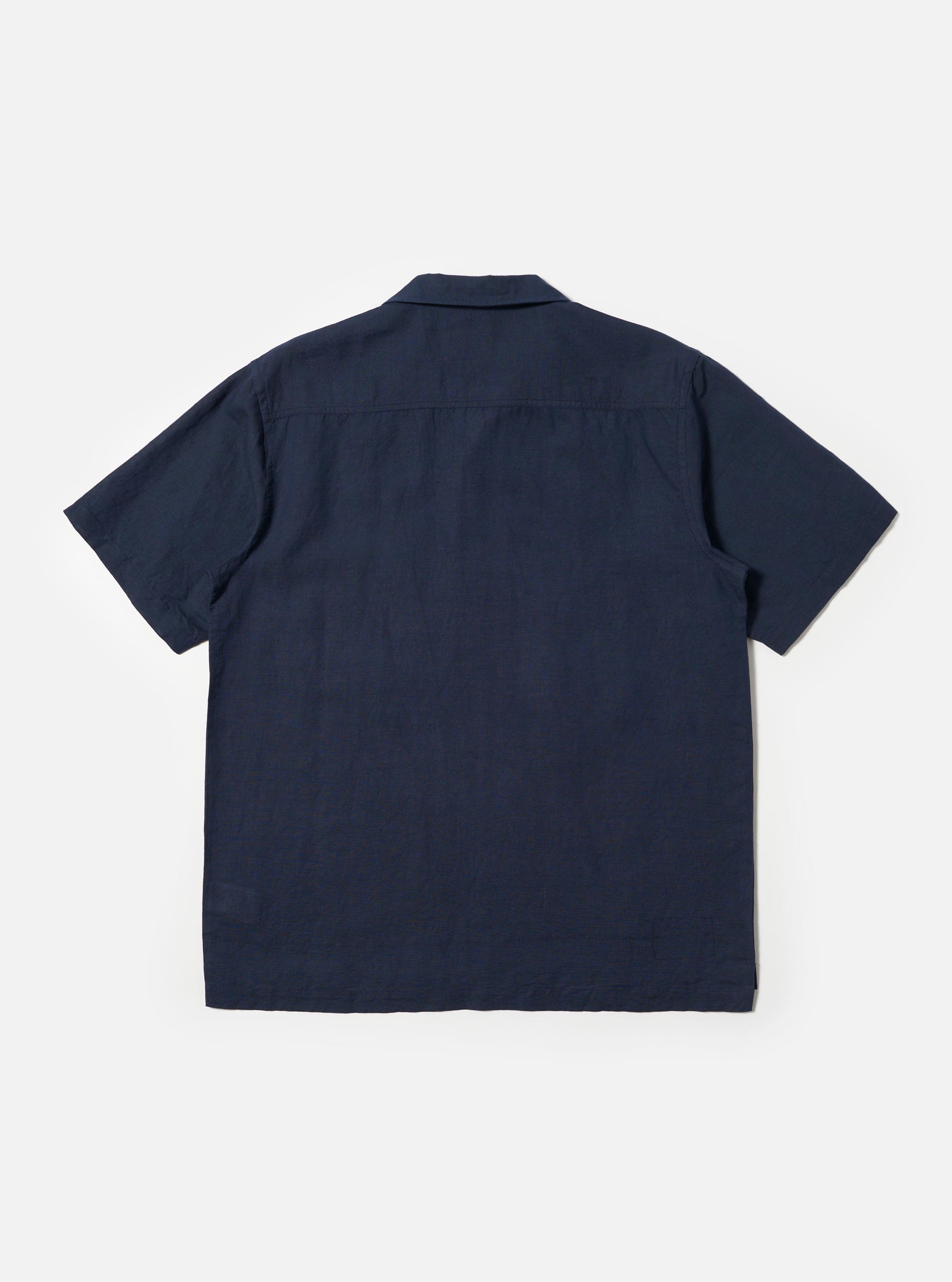 A male model is wearing the Navy Linen Cotton Shirting Camp Shirt against a plain white background. The shirt features short sleeves, a classic camp collar, and a button-down front. The model is shown from the chest up, highlighting the fabric texture and the relaxed fit of the collar. No mannequin is present in the image.