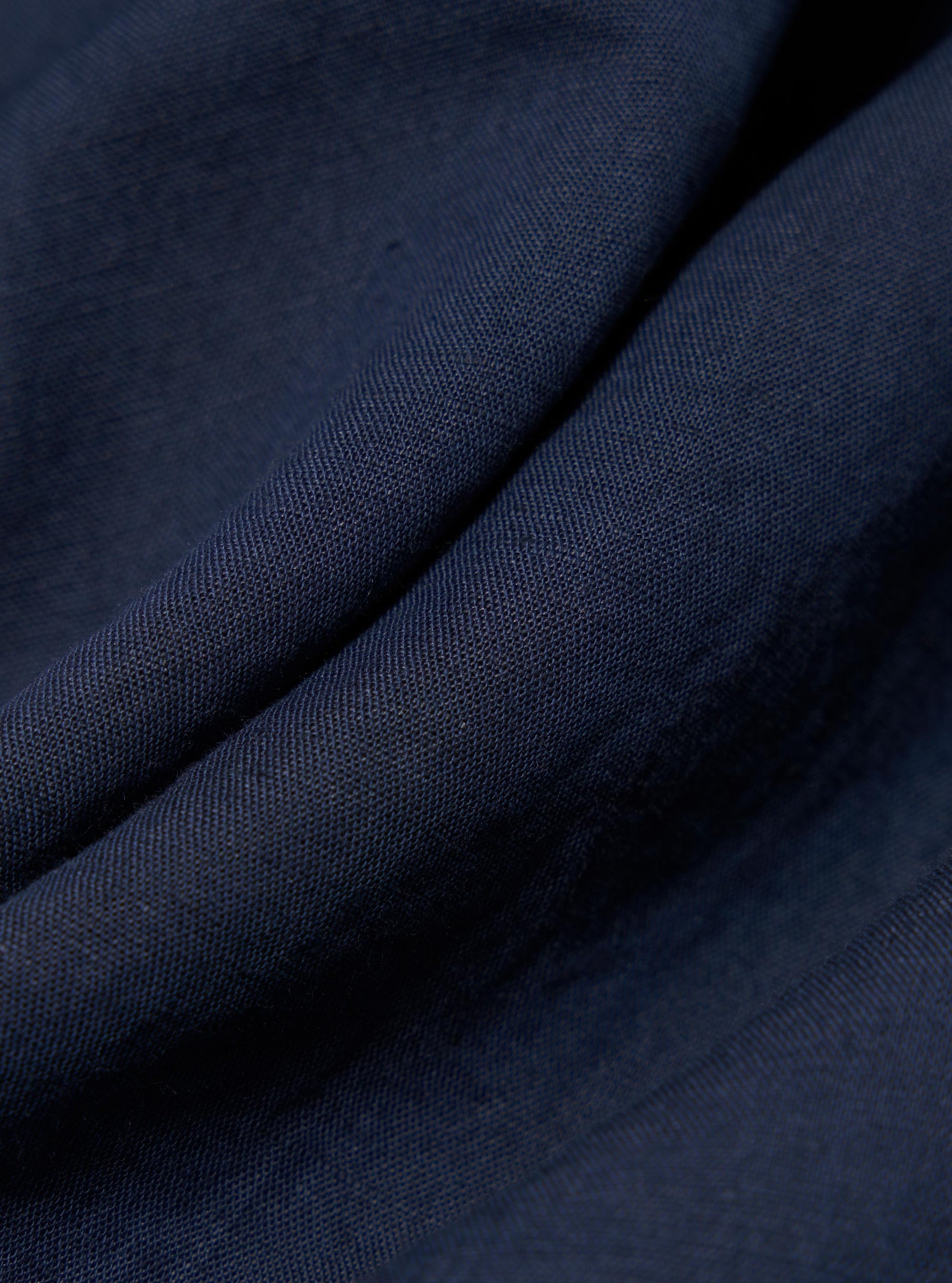A detailed, close-up fabric swatch of the Navy Linen Cotton Shirting Camp Shirt. The image highlights the textured weave of the navy blue linen-cotton blend fabric.