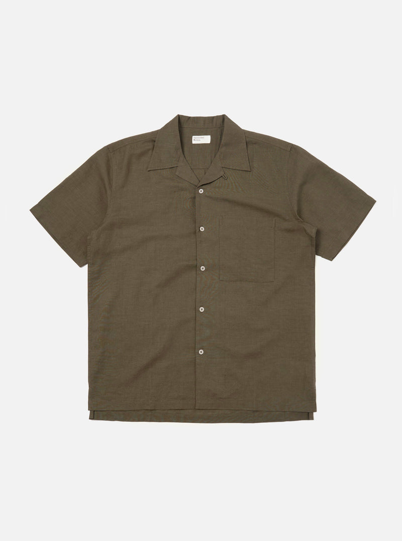 An Olive Linen Cotton Shirting Camp Shirt is displayed flat against a plain white background. The shirt features a relaxed fit with a one-piece camp collar, a full button-down front, and a single large patch pocket on the left chest. The short-sleeved garment is shown in a muted olive green color with a visible textured slub weave.