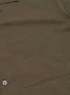 A rear view of the Olive Linen Cotton Shirting Camp Shirt is displayed flat against a plain white background. The image highlights the horizontal back yoke and the straight hemline of the garment.
