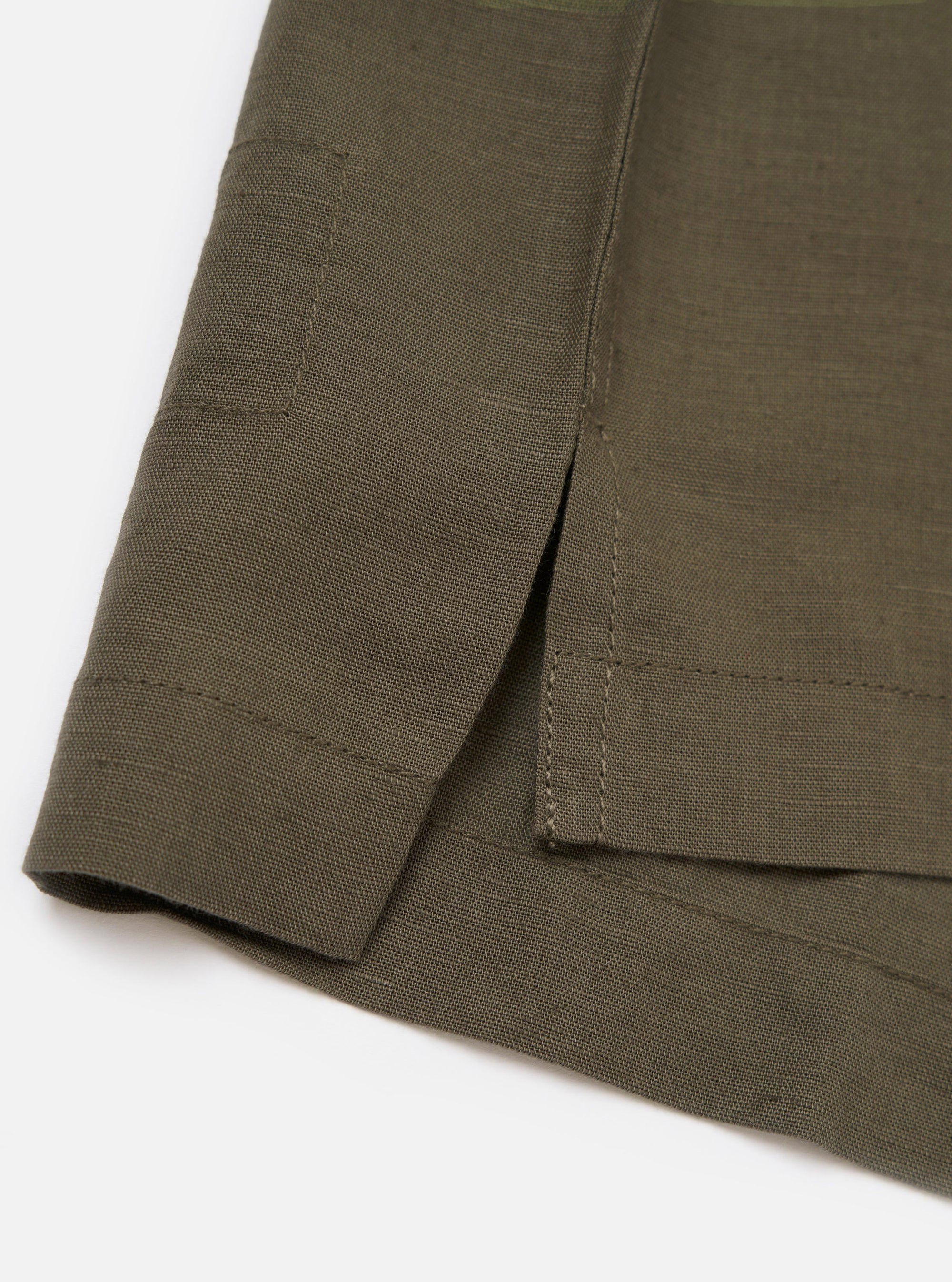 The Olive Linen Cotton Shirting Camp Shirt is shown from the back, laid flat against a plain white background. The image highlights the horizontal back yoke and the slightly elongated rear hem with side splits.
