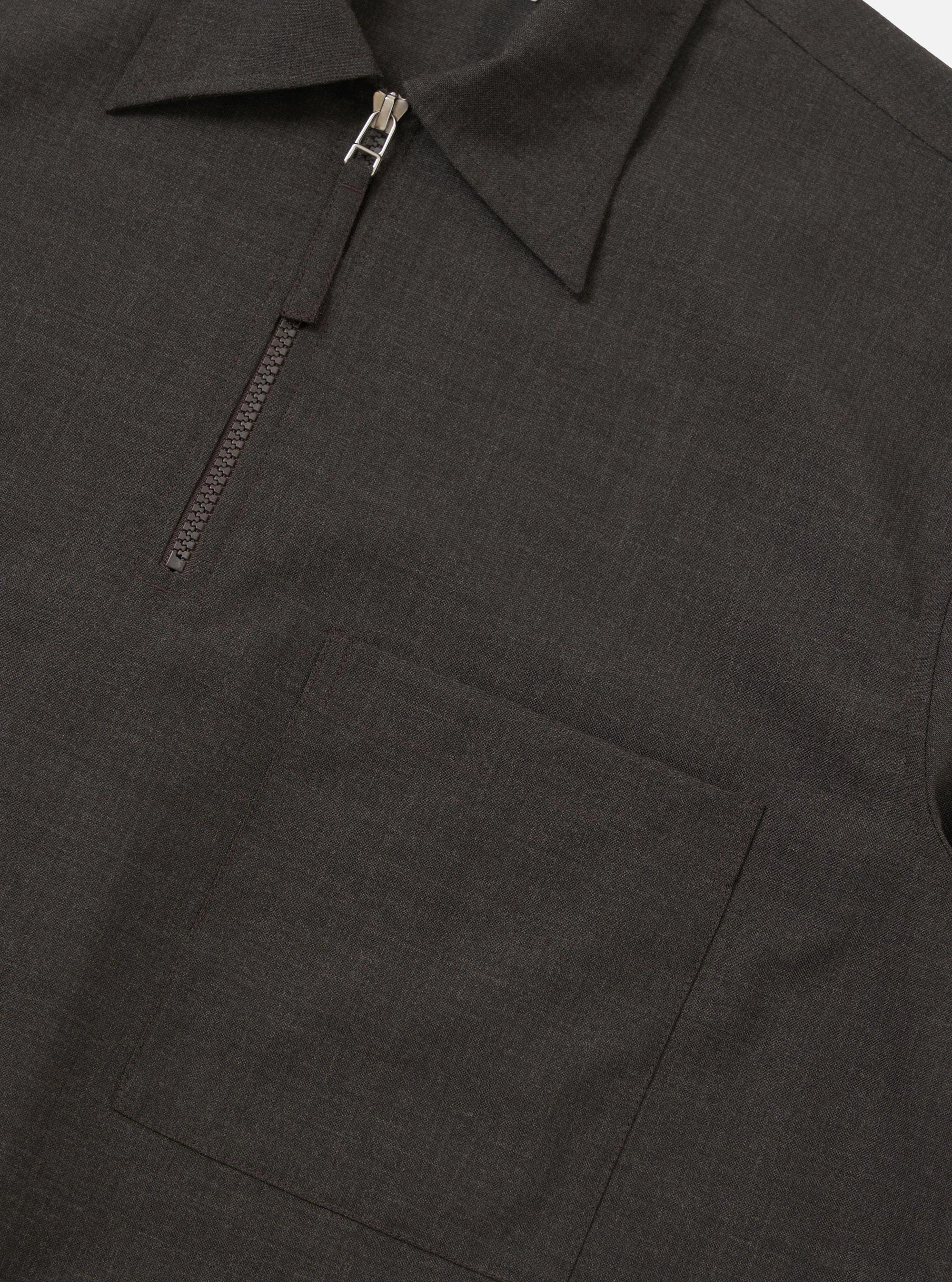 The Brown Marl Tropical Suiting Ewan Shirt is shown from the back, displayed flat against a plain white background. The image highlights the short sleeves, a straight hem with side splits, a back yoke, and a central box pleat.