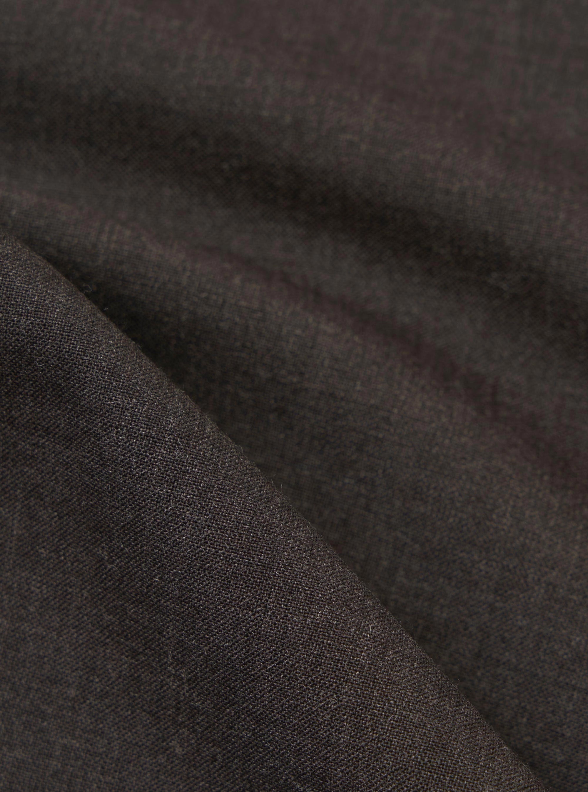 A detailed, close-up fabric swatch of the brown marl tropical suiting material used for the Ewan Shirt. The image highlights the fine weave and textured surface of the mottled brown fabric.