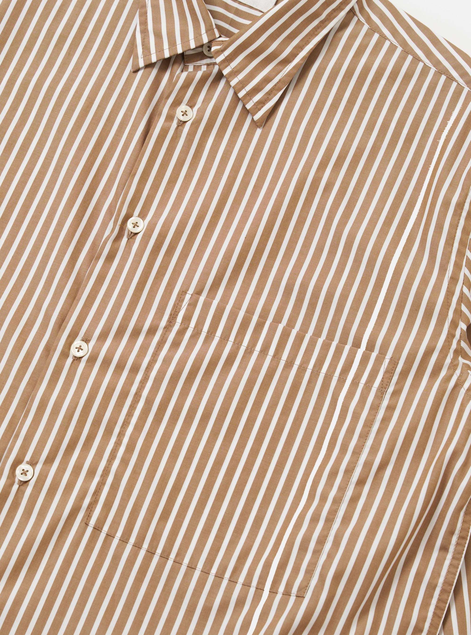 The Brown/White Cotton Stripe Square Pocket Shirt is shown from a rear perspective, laid flat against a plain white background. The shirt features a vertical brown and ecru stripe pattern, a straight hem, and a back yoke with a central box pleat.