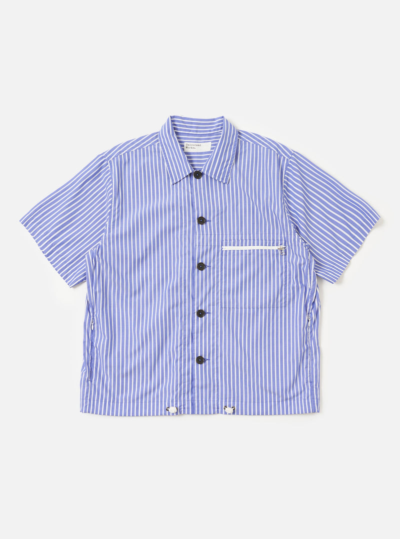 The Blue/White Cotton Stripe Z Tech Overshirt is shown laid flat against a solid white background. The garment features a vertical blue and white stripe pattern, a classic pointed collar, and a full button-down front. A single vertical zipped pocket is prominent on the left chest. The overshirt has long sleeves with elasticated cuffs and an elasticated drawcord hem.