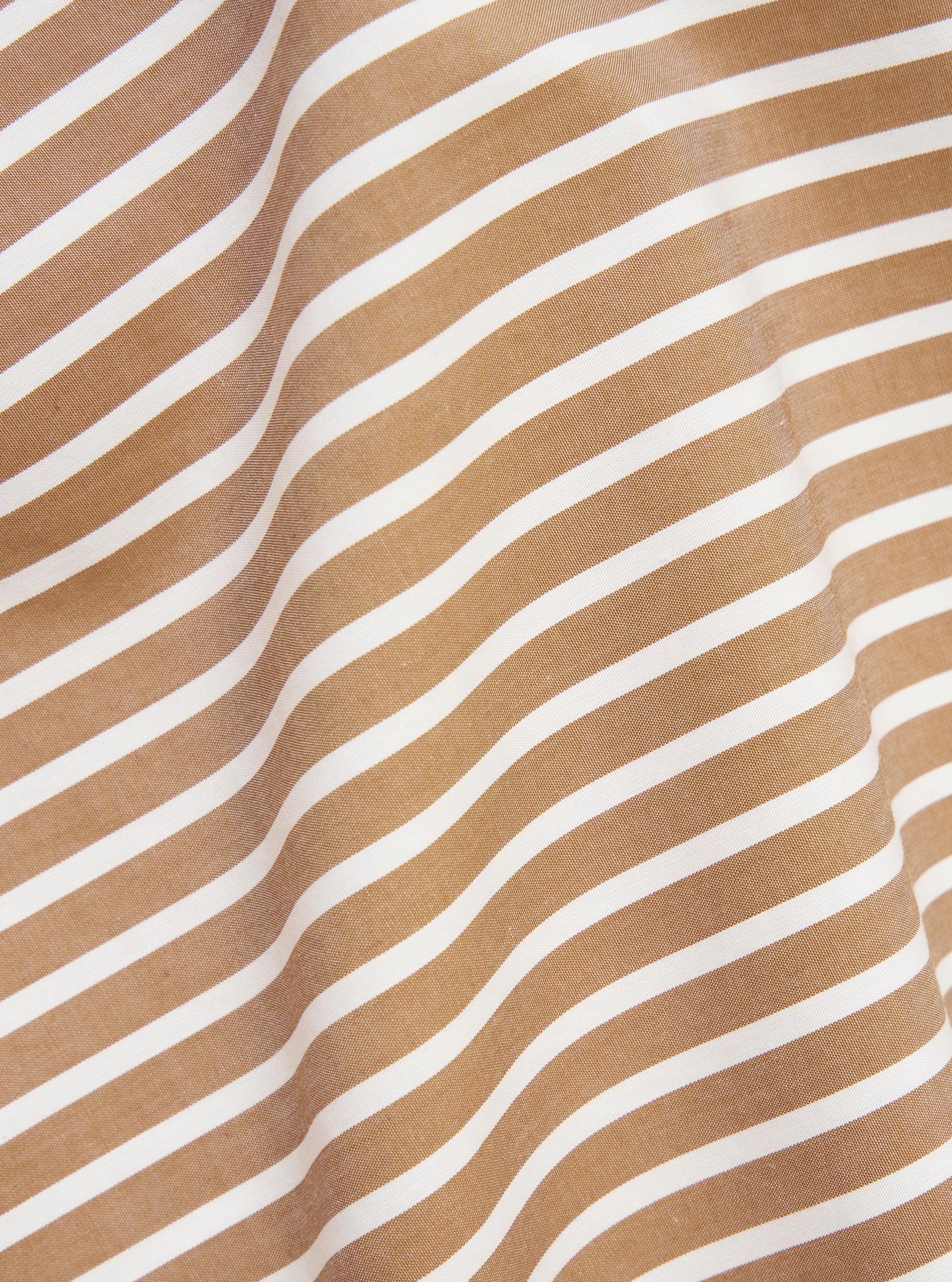 A close-up fabric swatch of the Brown/White Cotton Stripe Z Tech Overshirt displays a detailed pattern of thin, vertical brown and white stripes. The image focuses on the fine texture and weave of the cotton material.