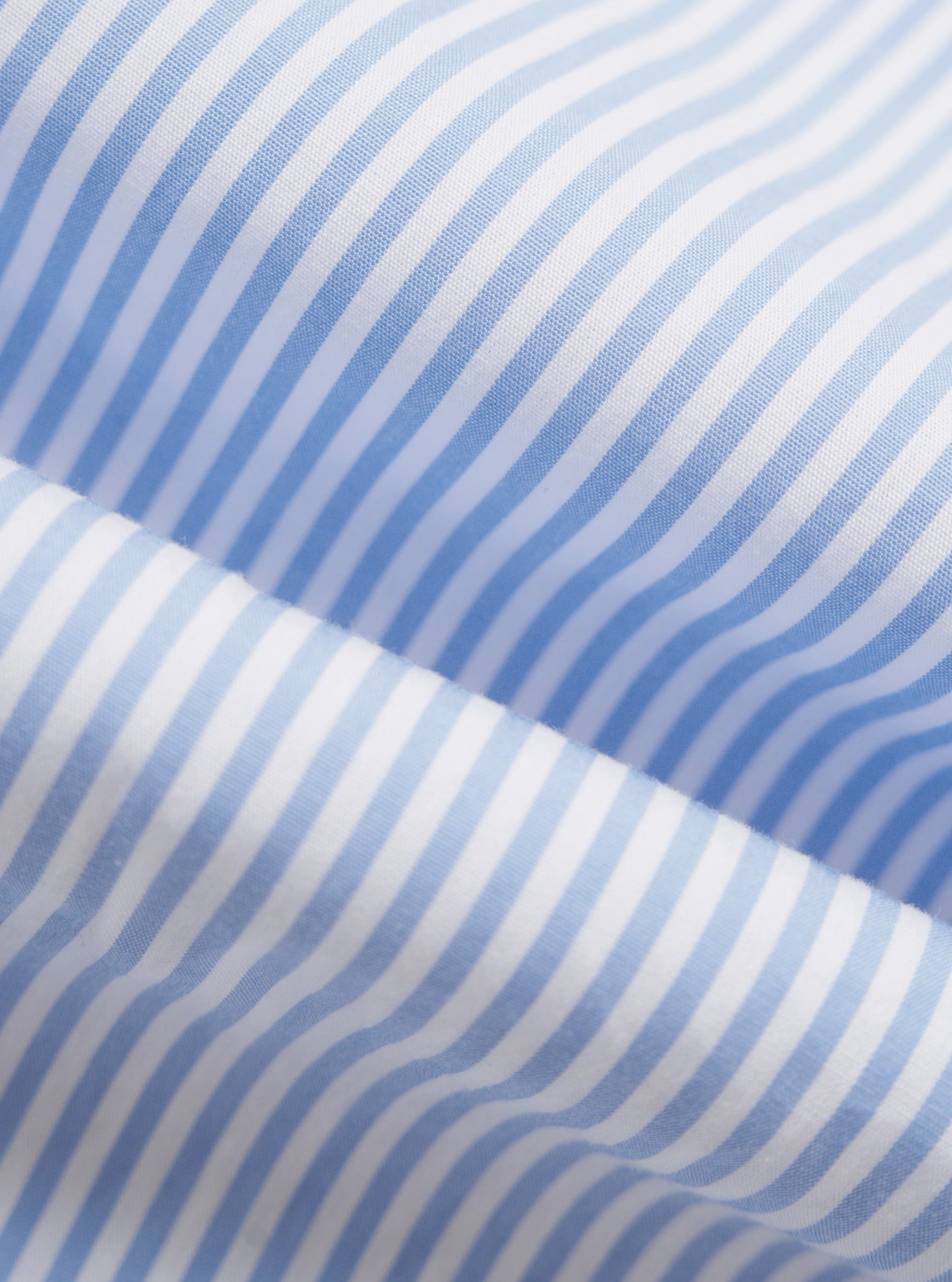 A detailed, close-up fabric swatch of the Sky/White Classic Nipon Stripe Ewan Shirt. The image highlights the vertical sky blue and white striped pattern and the textured weave of the cotton fabric.