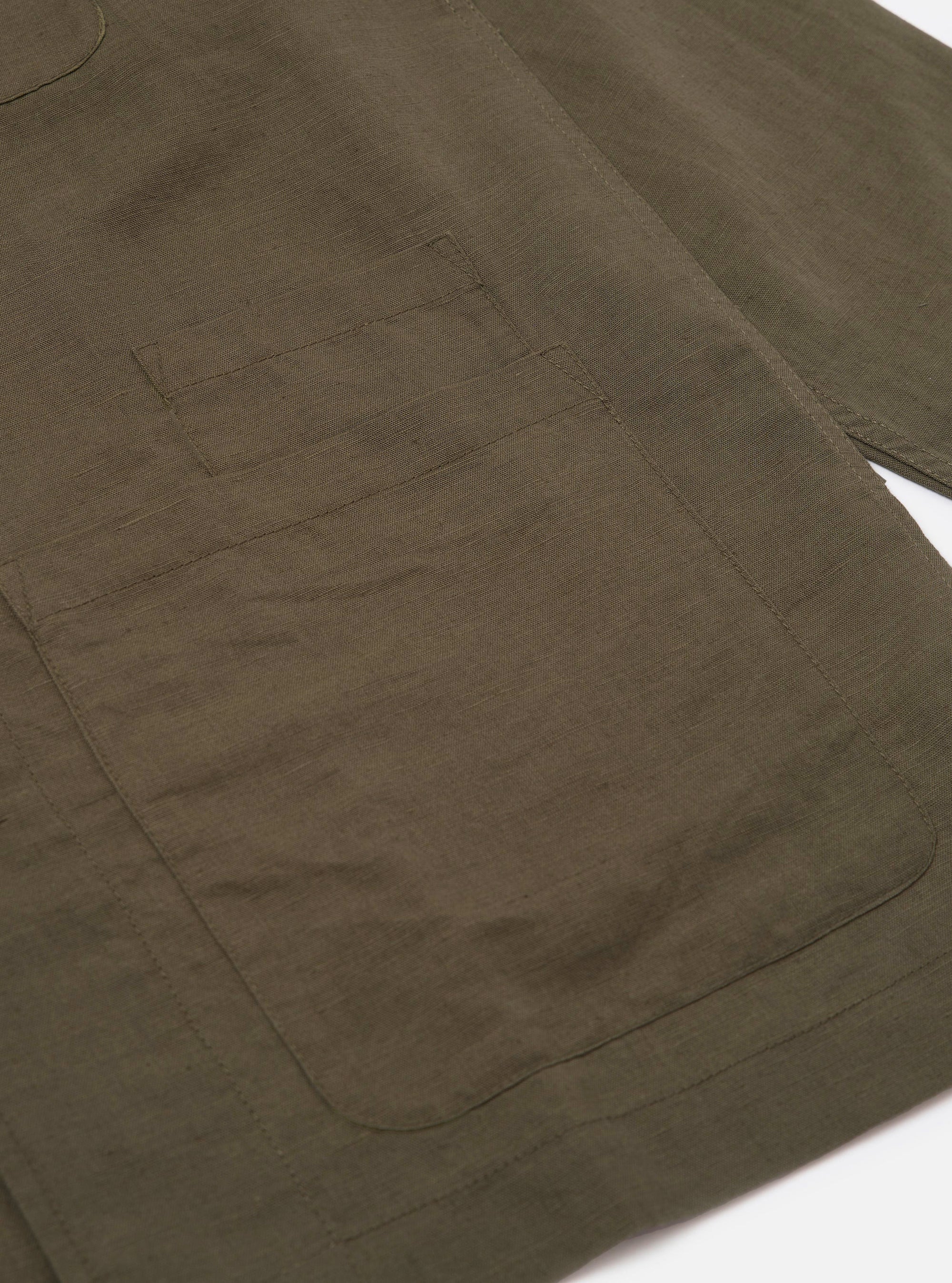 An Olive Linen Cotton Shirting Bakers Overshirt is shown from the back, displayed flat against a plain white background. The image highlights the straight-cut hem and the texture of the olive green linen-cotton fabric.