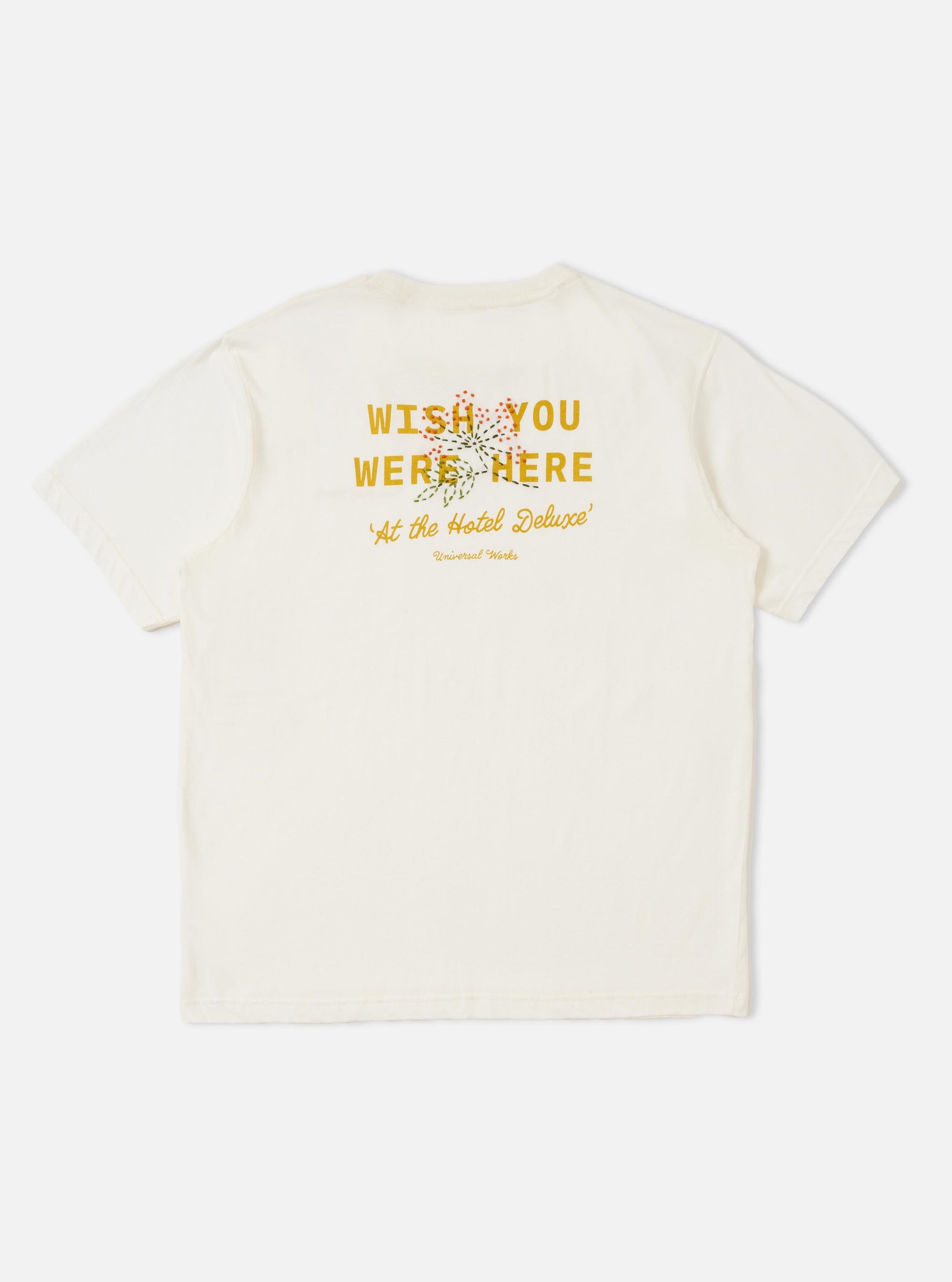 The back of the Ecru Single Jersey Wish Wish You Were Here Tee is displayed flat against a plain white background. The short-sleeved t-shirt features a large printed graphic on the back with Wish You Were Here text and a hand-embroidered floral spray overlay.