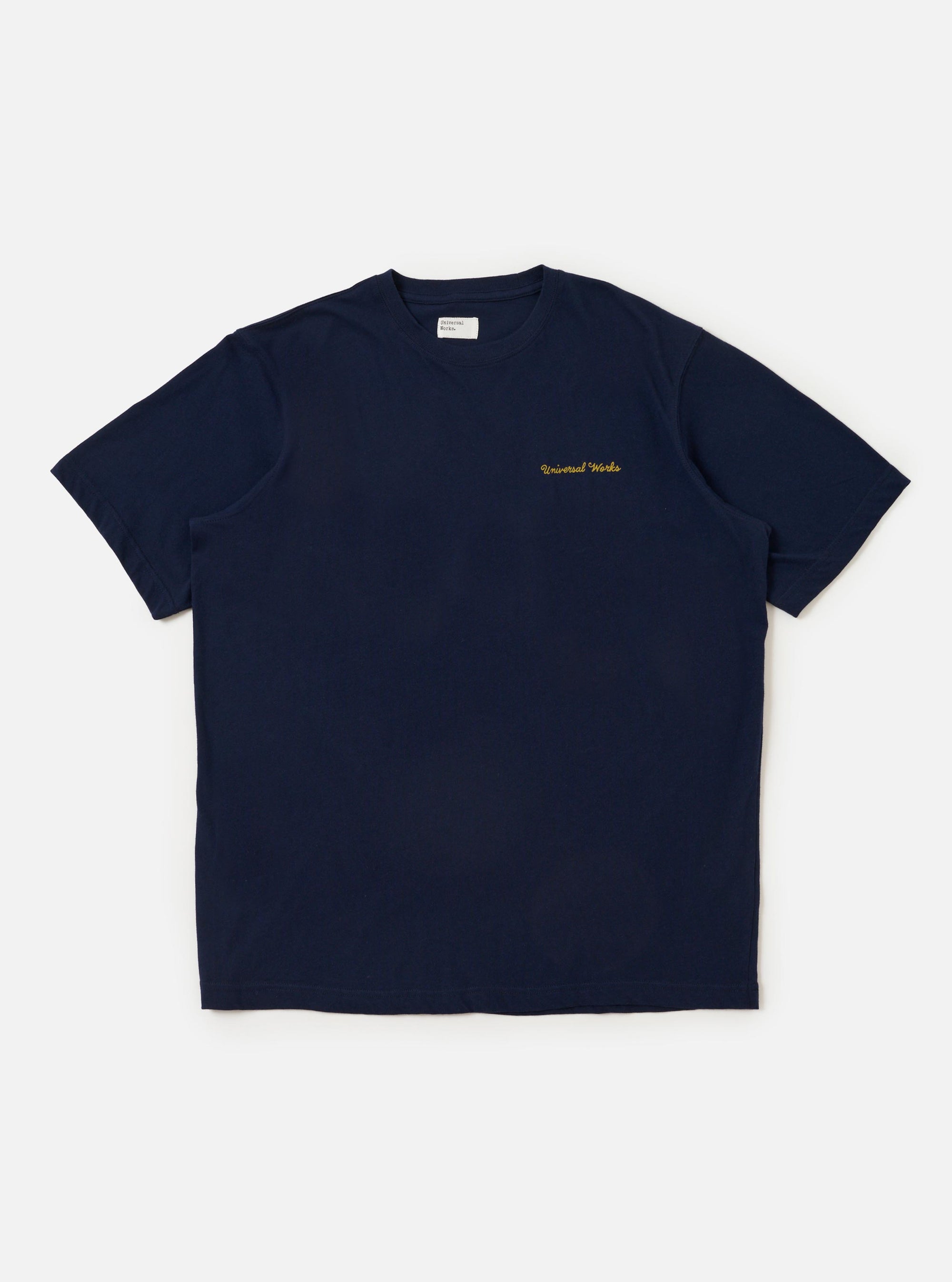 The Navy Single Jersey Wish Wish You Were Here Tee is shown laid flat against a solid white background. The navy blue t-shirt features a crew neckline and a short-sleeve silhouette. A white graphic print is prominent on the center of the chest.