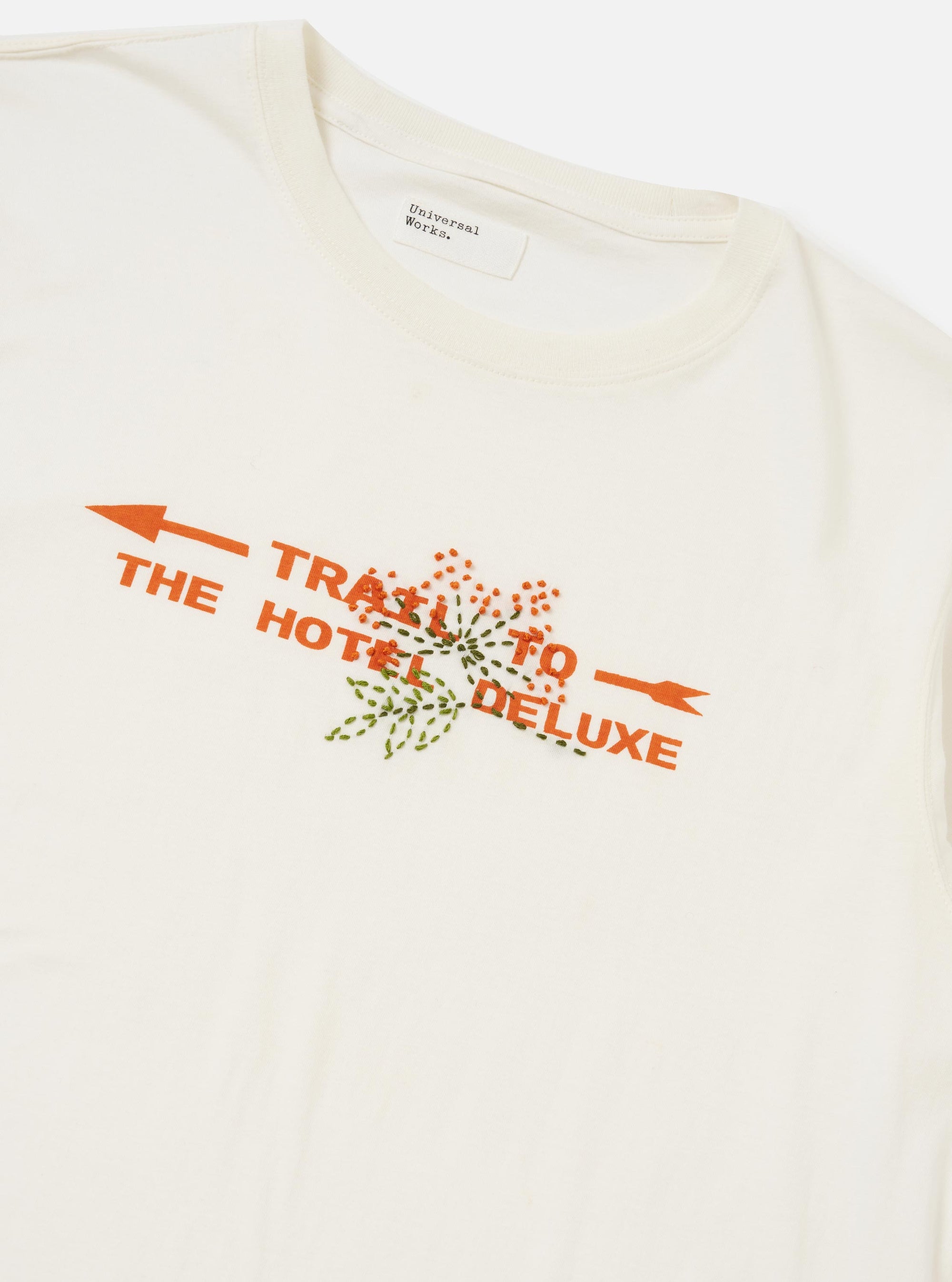 The Ecru Single Jersey Trail Trail To Hotel Delux Tee is shown from the back, laid flat against a plain white background. The image highlights the ecru-colored cotton fabric, a classic crew neck, and short sleeves.