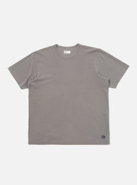 A mid-grey piquet core tee is shown laid flat against a solid white background. The short-sleeved t-shirt features a classic crew neck with a self-bound collar and a straight hem, highlighting the textured piquet cotton fabric.