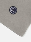 A mid grey piquet core tee is shown from the back, laid flat against a solid white background. The image highlights the short sleeves, a straight hem, and a simple crew neck with a self-bound finish.