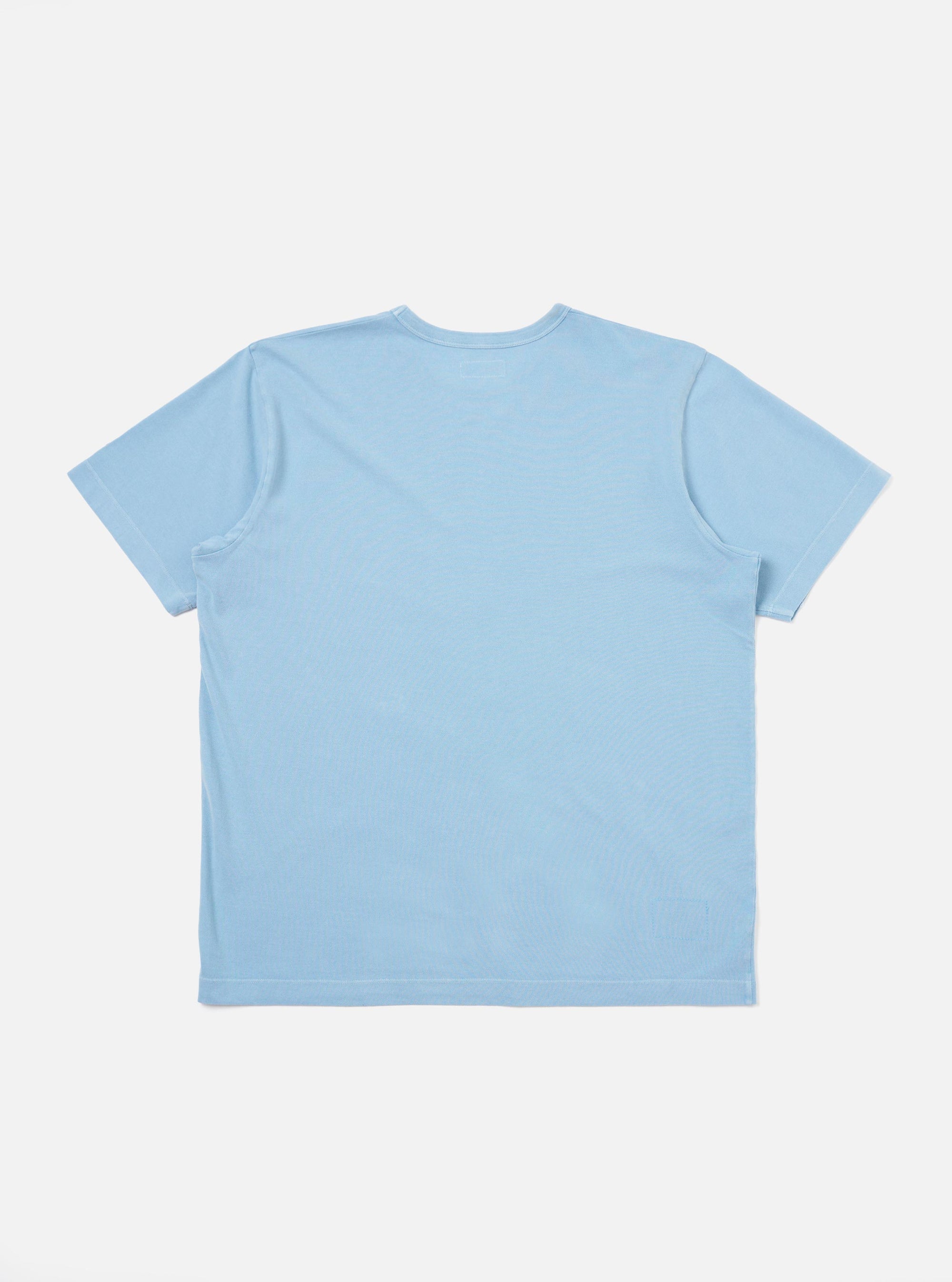 The Pale Blue Piquet Core Tee is shown from a rear perspective, laid flat against a solid white background. The image highlights the short sleeves, a straight hem, and the textured piquet cotton fabric.