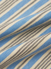 A close-up fabric swatch of the Pale Blue OS Stripe Jersey Core Tee displays a pattern of horizontal white and pale blue stripes. The image focuses on the fine, ribbed texture of the cotton jersey material.