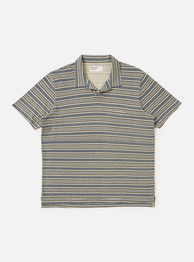 A Grey OS Stripe Jersey Vacation Polo is shown laid flat against a solid white background. The shirt features horizontal light grey and charcoal stripes with an irregular, hand-painted character. It has a relaxed open neck with a single-piece collar, a short front placket, a single patch chest pocket, and a straight hem.