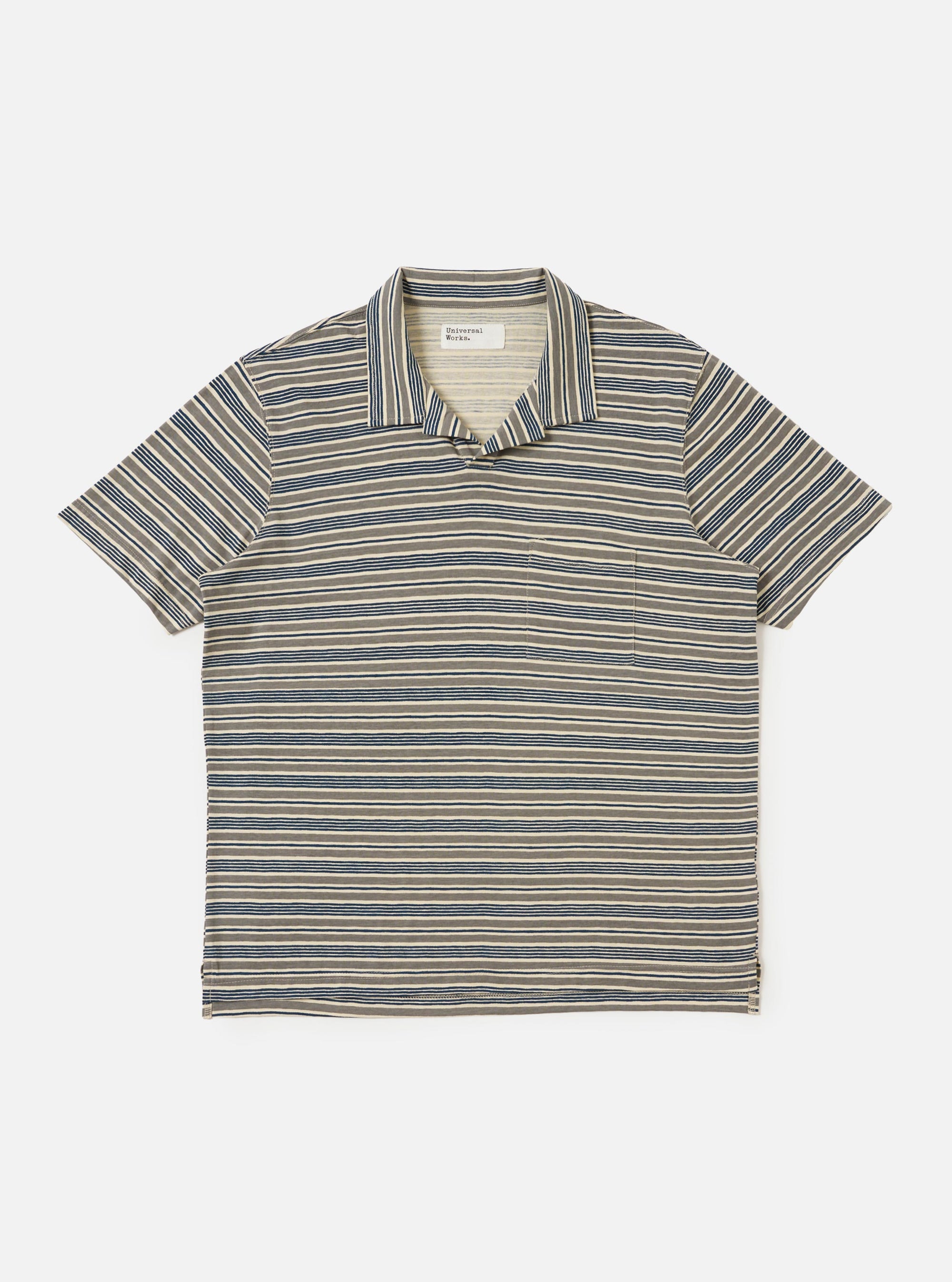 A Grey OS Stripe Jersey Vacation Polo is shown laid flat against a solid white background. The shirt features horizontal light grey and charcoal stripes with an irregular, hand-painted character. It has a relaxed open neck with a single-piece collar, a short front placket, a single patch chest pocket, and a straight hem.