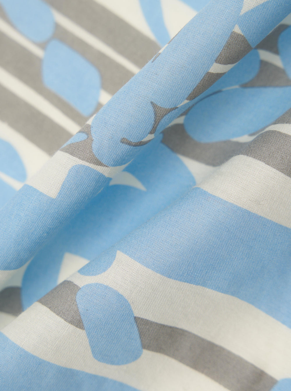A close-up fabric swatch of the Ecru Cambric Neckerchief highlights the fine, lightweight weave of the off-white cotton material. The image focuses on the texture and subtle matte finish of the fabric.