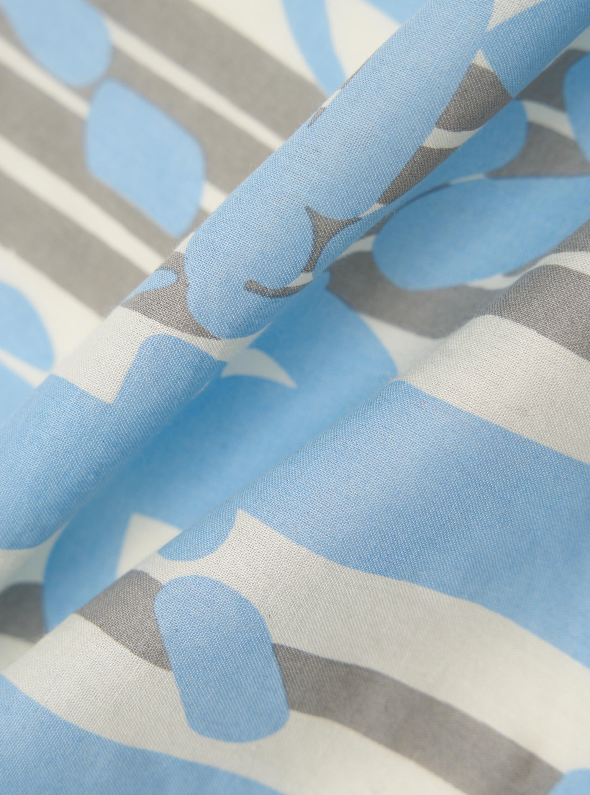 A close-up fabric swatch of the Ecru Cambric Neckerchief highlights the fine, lightweight weave of the off-white cotton material. The image focuses on the texture and subtle matte finish of the fabric.