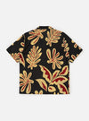 The Black Baja Print Road Shirt is shown from the back, laid flat against a plain white background. The image highlights the shirt's straight hem and the intricate, all-over white patterned print against the black cotton fabric.