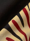 A close-up fabric swatch of the Black Baja Print Road Shirt features a detailed view of the 100% cotton material. The fabric has an all-over intricate patterned print in shades of black, grey, and white. The image focuses on the texture of the weave and the complexity of the print design.