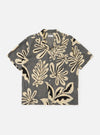 The Grey Baja Print Road Shirt is shown laid flat against a solid white background. The short-sleeve shirt features a grey and white botanical print throughout, a relaxed camp collar, a button-down front, and a single chest patch pocket.