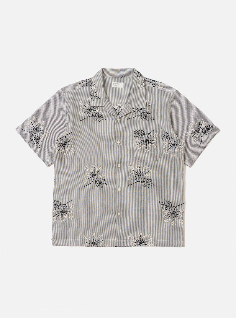 The Grey Hand Embroidered Stripe Cotton Road Shirt is shown laid flat against a solid white background. The shirt features a camp collar, a full button-down front, and short sleeves. The grey cotton fabric is detailed with vertical hand-embroidered stripes in a contrasting dark tone.