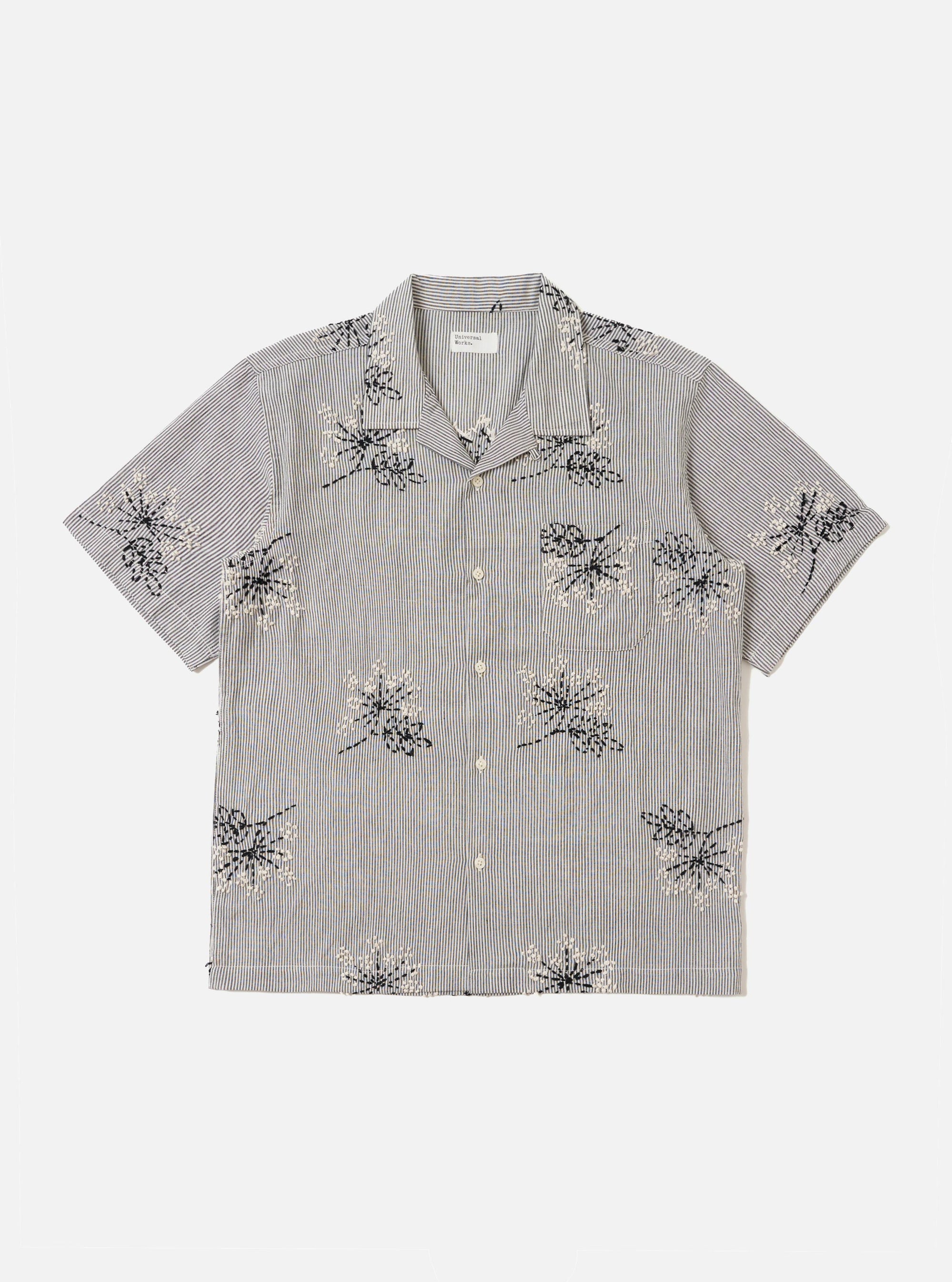 The Grey Hand Embroidered Stripe Cotton Road Shirt is shown laid flat against a solid white background. The shirt features a camp collar, a full button-down front, and short sleeves. The grey cotton fabric is detailed with vertical hand-embroidered stripes in a contrasting dark tone.