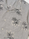 The Grey Hand Embroidered Stripe Cotton Road Shirt is shown from the back, displayed flat against a plain white background. The image highlights the horizontal hand-embroidered stripe pattern in grey and white, the short sleeves, and a straight hem.
