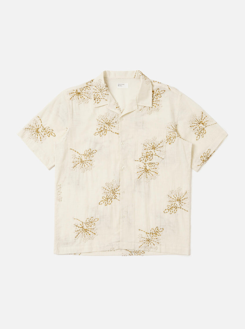 An Ecru Hand Embroidered Cotton Road Shirt is displayed flat against a plain white background. The short-sleeve shirt features a camp collar, a full button-down front, and a single patch pocket on the left chest. Intricate hand-embroidered stripe patterns in a darker thread are prominent across the entire garment.