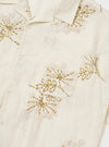 An Ecru Hand Embroidered Cotton Road Shirt is displayed flat against a plain white background. The shirt features a camp collar, a button-down front, and a single chest patch pocket on the left side. Hand-embroidered floral motifs are scattered across the ecru fabric.
