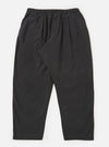 A pair of charcoal grey cotton pleated track pants is displayed flat against a plain white background. The trousers feature an elasticated waistband with a drawstring, a single pleat at the front of each leg, and side pockets.