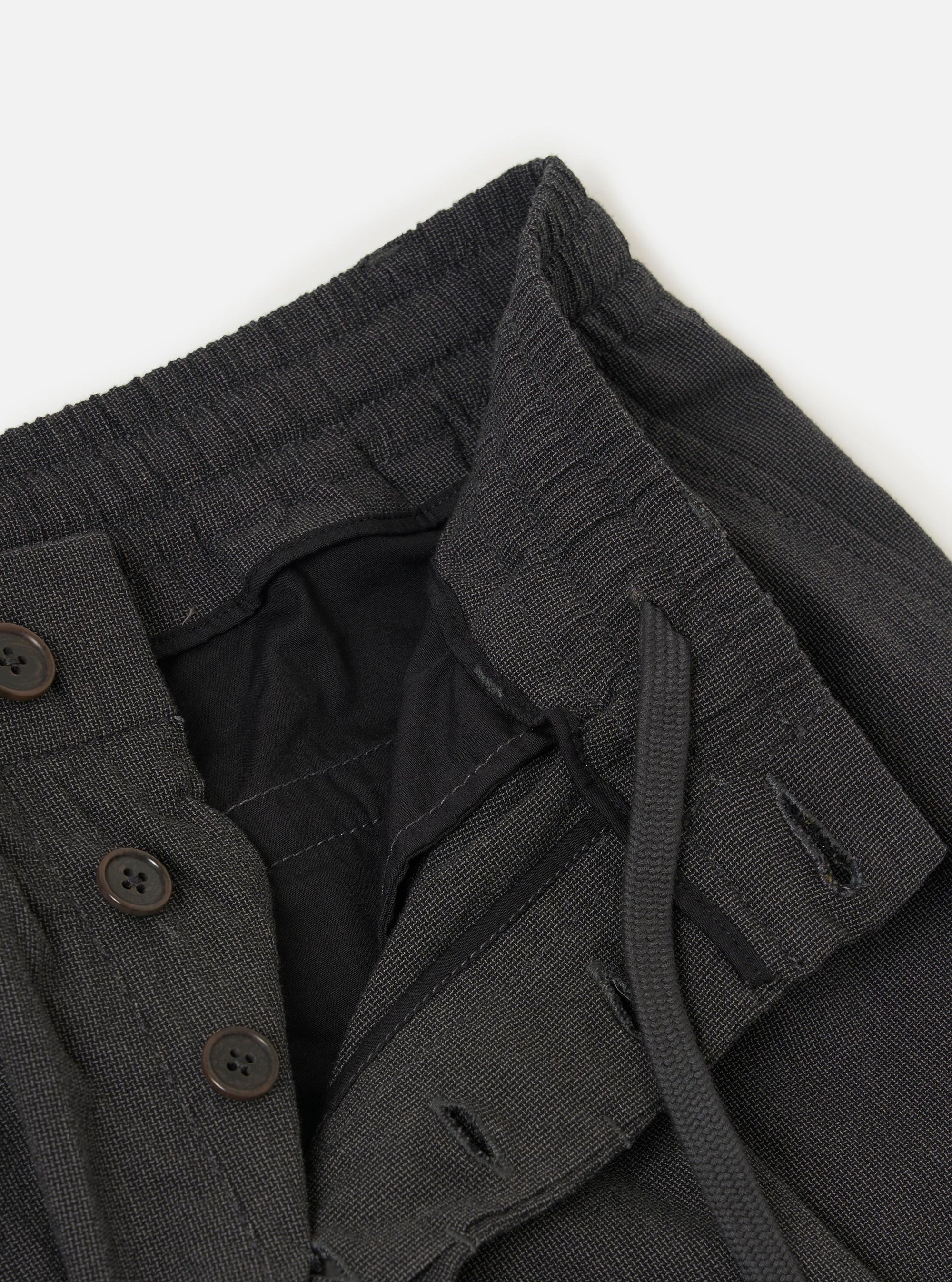 The Charcoal Seattle Cotton Pleated Track Pant is displayed flat against a plain white background. The charcoal grey trousers feature a relaxed fit with a tapered leg, a single pleat on each leg for added volume, and an elasticated waistband with a visible drawstring.
