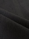 A detailed, close-up fabric swatch of the charcoal grey Seattle cotton material used for the Pleated Track Pant. The image highlights the fine basket weave and textured surface of the cotton fabric.