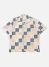 A Pastel Check Patchwork Camp Shirt is displayed flat against a plain white background. The shirt features a multi-colored patchwork design consisting of various checkered patterns in pastel shades. Key details include a relaxed camp collar, a full button-down front, short sleeves, and a single large patch pocket on the left chest.