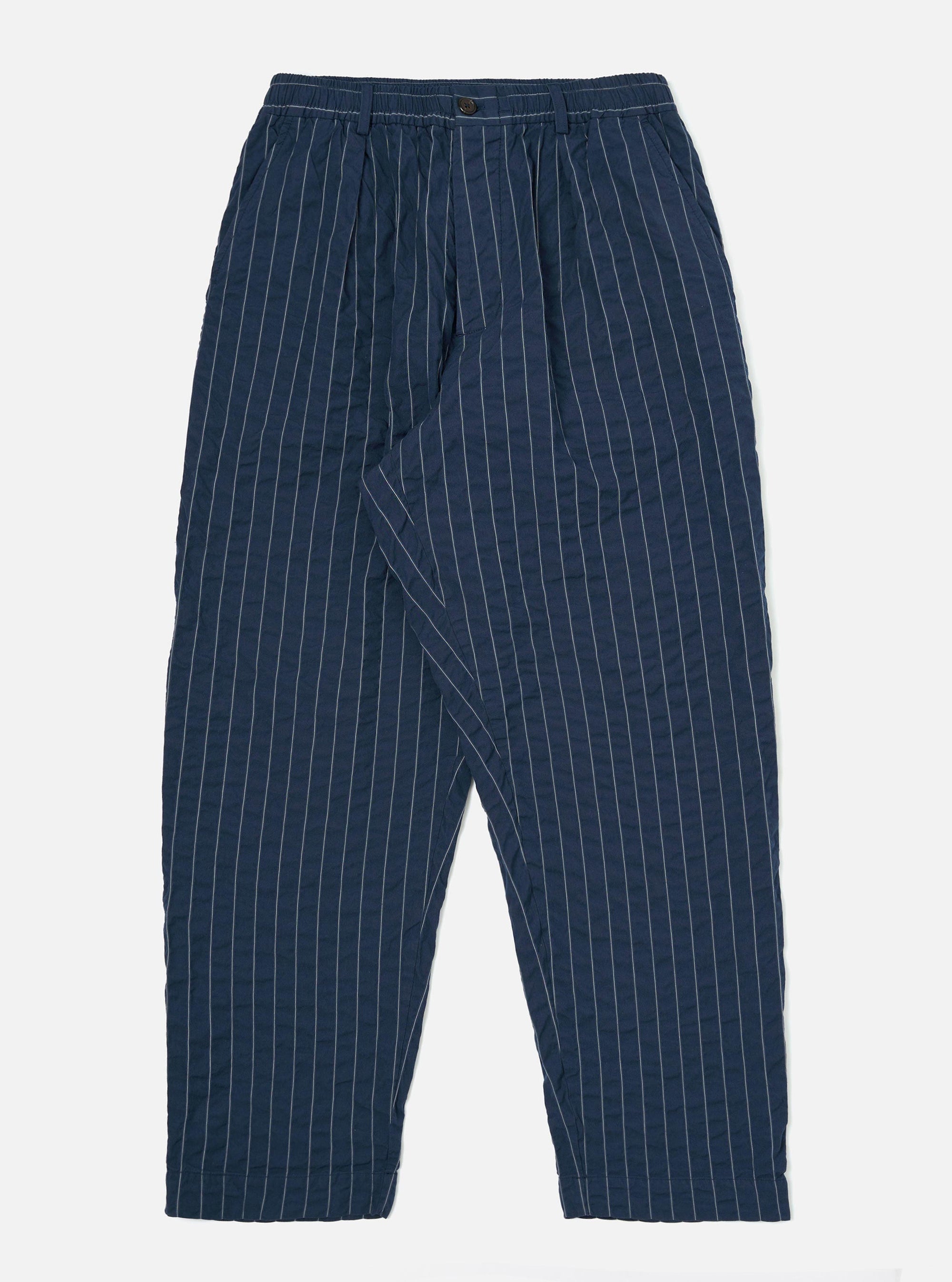 The Navy Chester Stripe Oxford Pant is displayed flat against a plain white background. The trousers feature a loose, wide-leg fit with vertical navy and white pinstripes, a drawstring waistband, and a single pleat in the front.