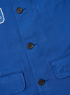 Close-up of the Paraboot x Universal Works Navy Derek Twill Warmus Jacket. Features include a navy twill material, button closure, and chest pockets. 