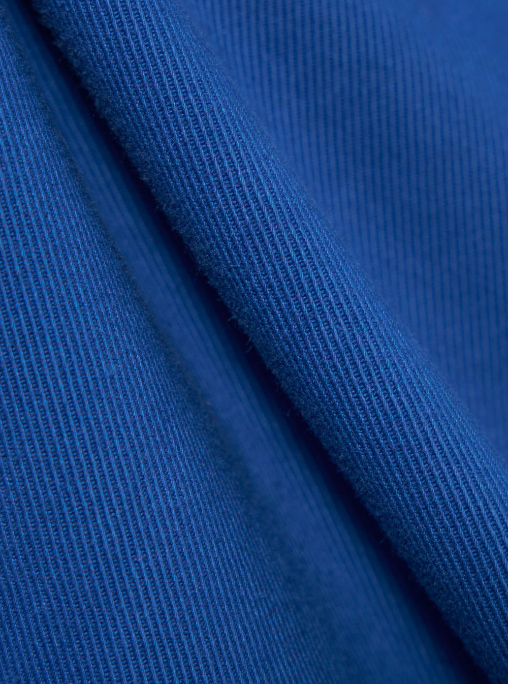 Close-up of the Paraboot x Universal Works Navy Derek Twill Super Chino fabric. The twill weave is visible in the bright navy material.