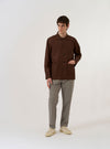 A close-up fabric swatch of the Brown Peached Poplin Bakers Overshirt is shown, highlighting the fine, tight plain weave and the soft, brushed surface of the brown cotton fabric.