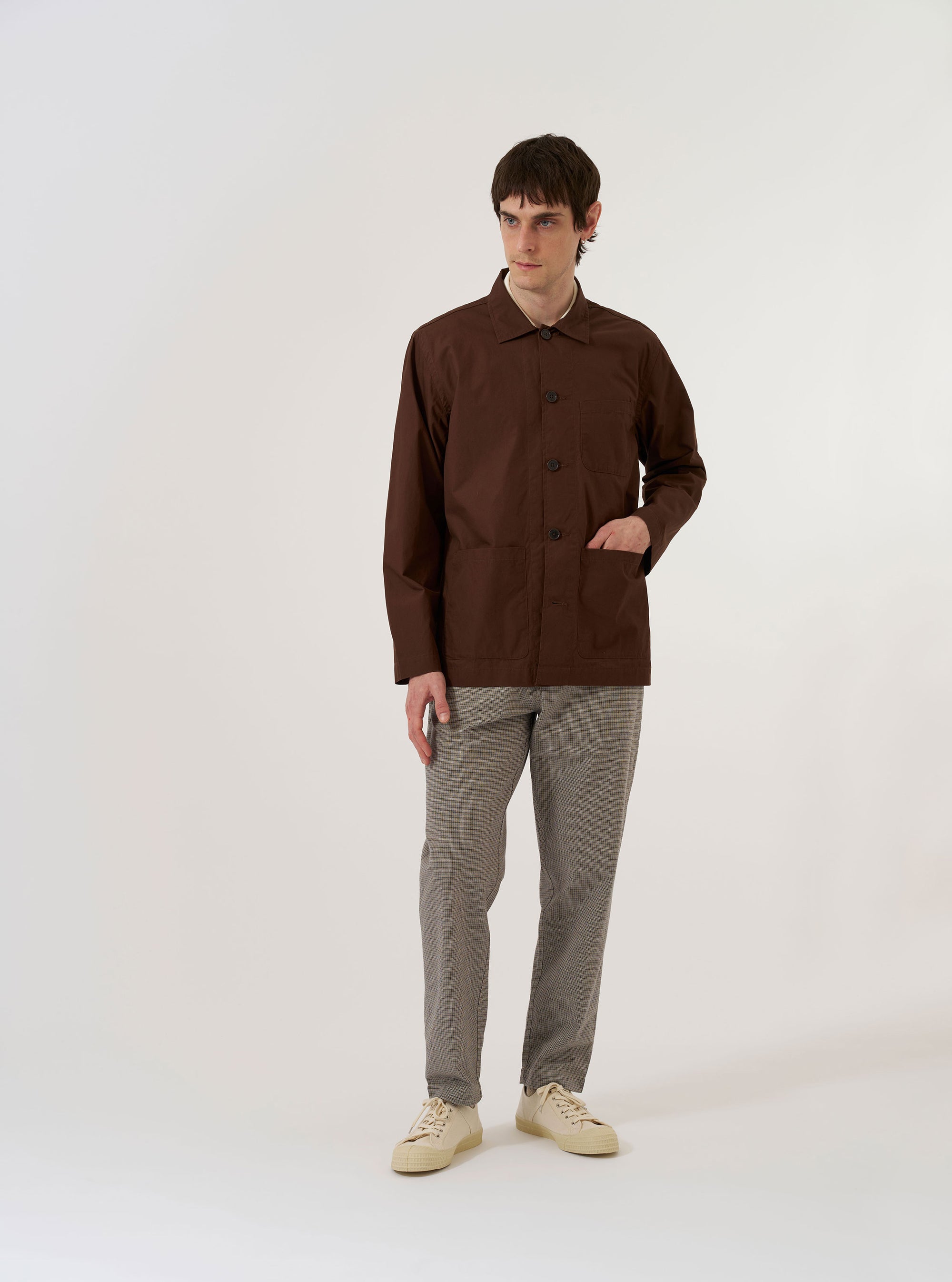 A close-up fabric swatch of the Brown Peached Poplin Bakers Overshirt is shown, highlighting the fine, tight plain weave and the soft, brushed surface of the brown cotton fabric.