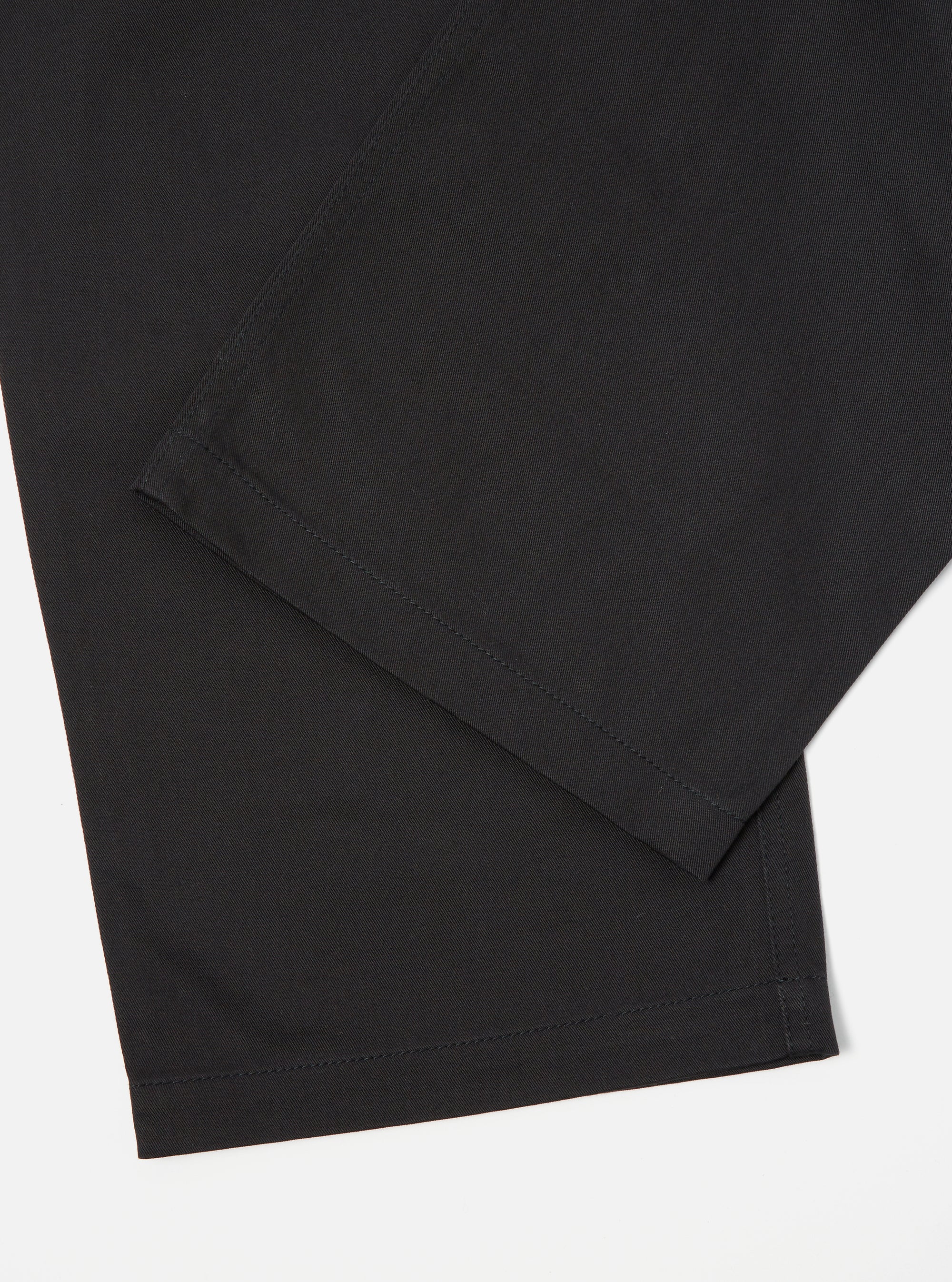 Close-up of the Black Twill Fatigue Pant (Undarted) on a white surface. The dark, durable twill fabric is clearly visible, showcasing the pant's clean lines and classic fit.