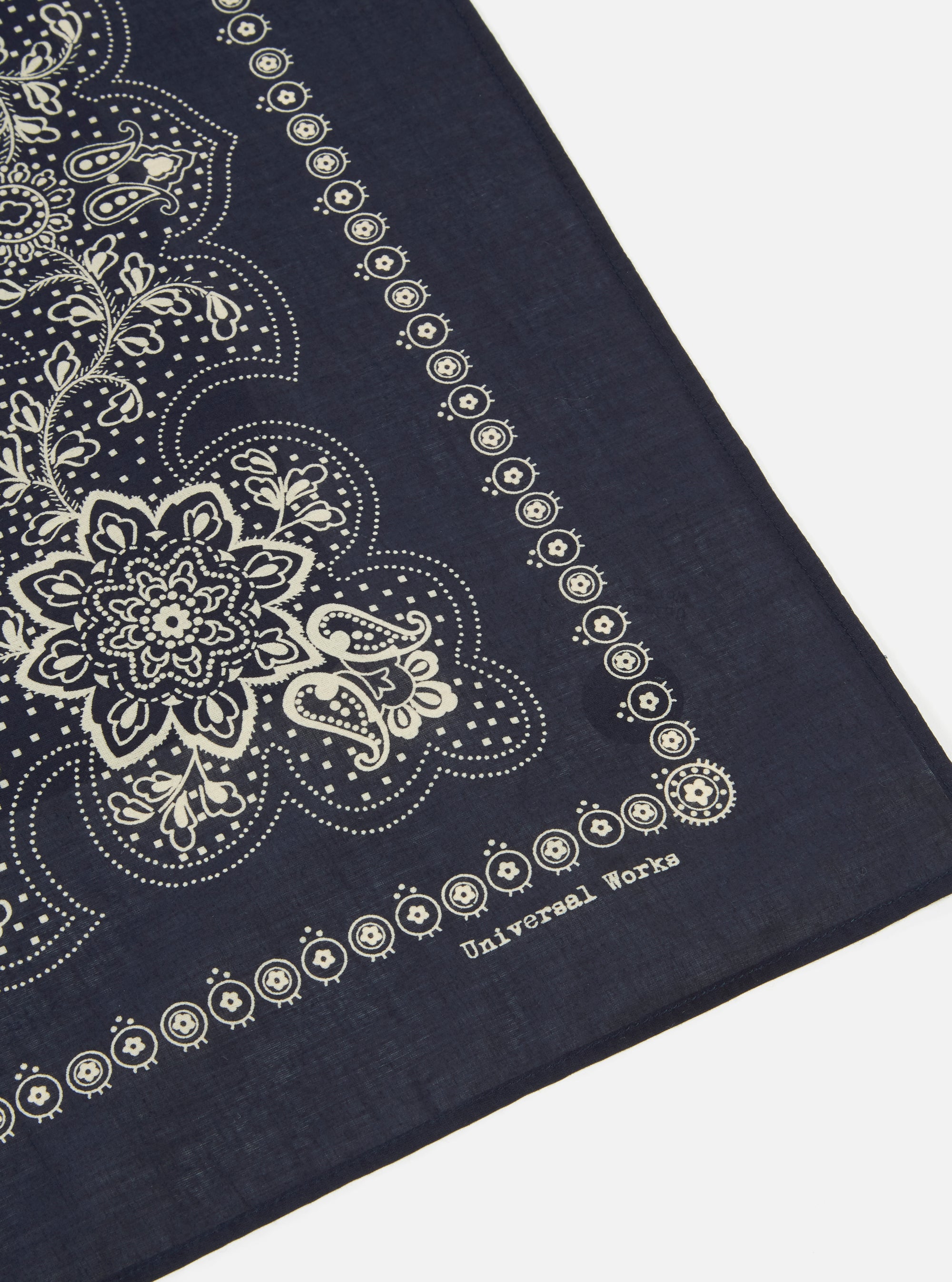 Close-up of a Navy Classic Bandana Neckerchief on a white background. The bandana has a paisley pattern in white ink. The fabric is a dark navy.