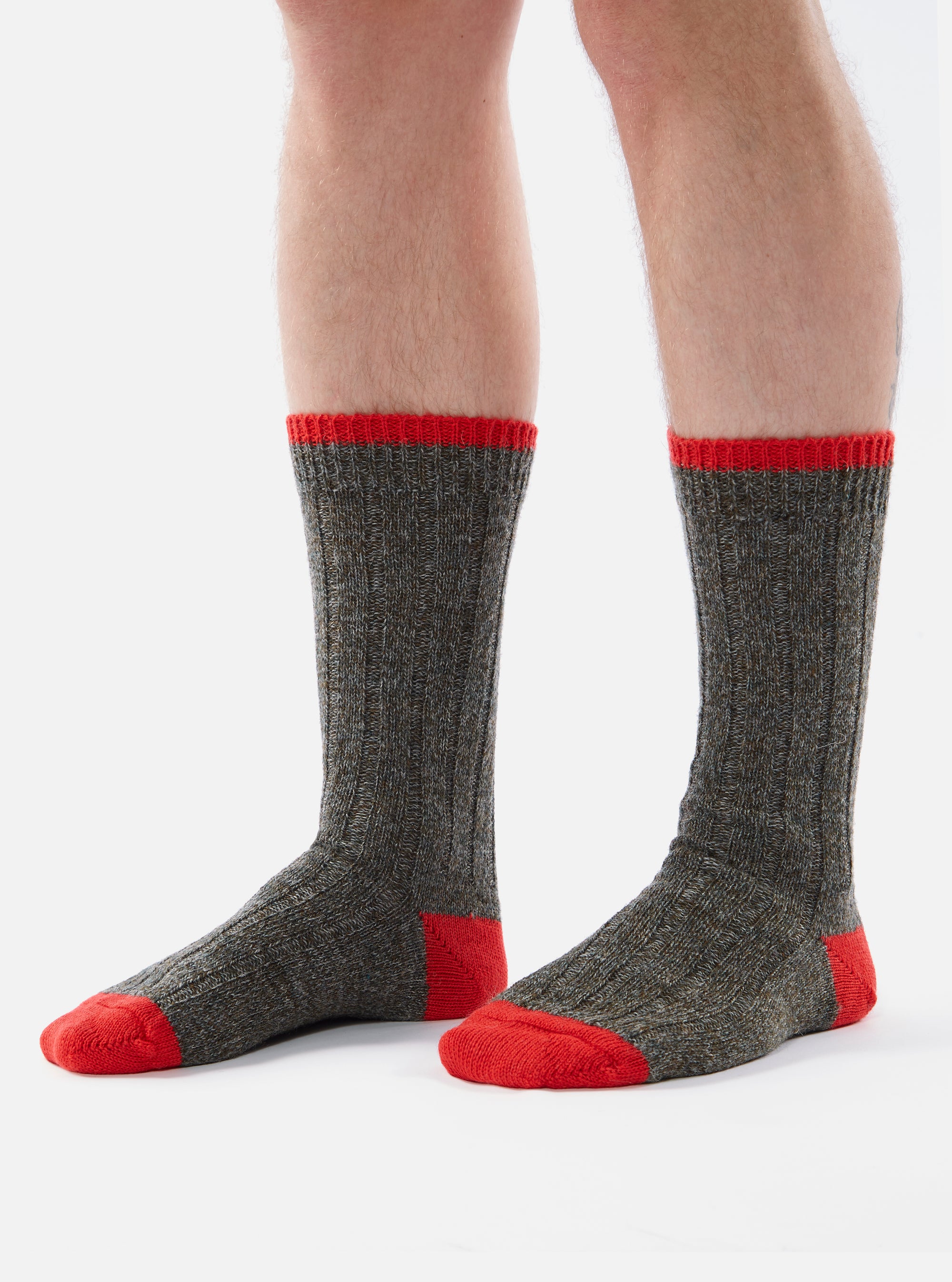 Close-up of a person wearing Derby Wool Hike Sock on a white background. The sock is gray with a red toe and cuff.