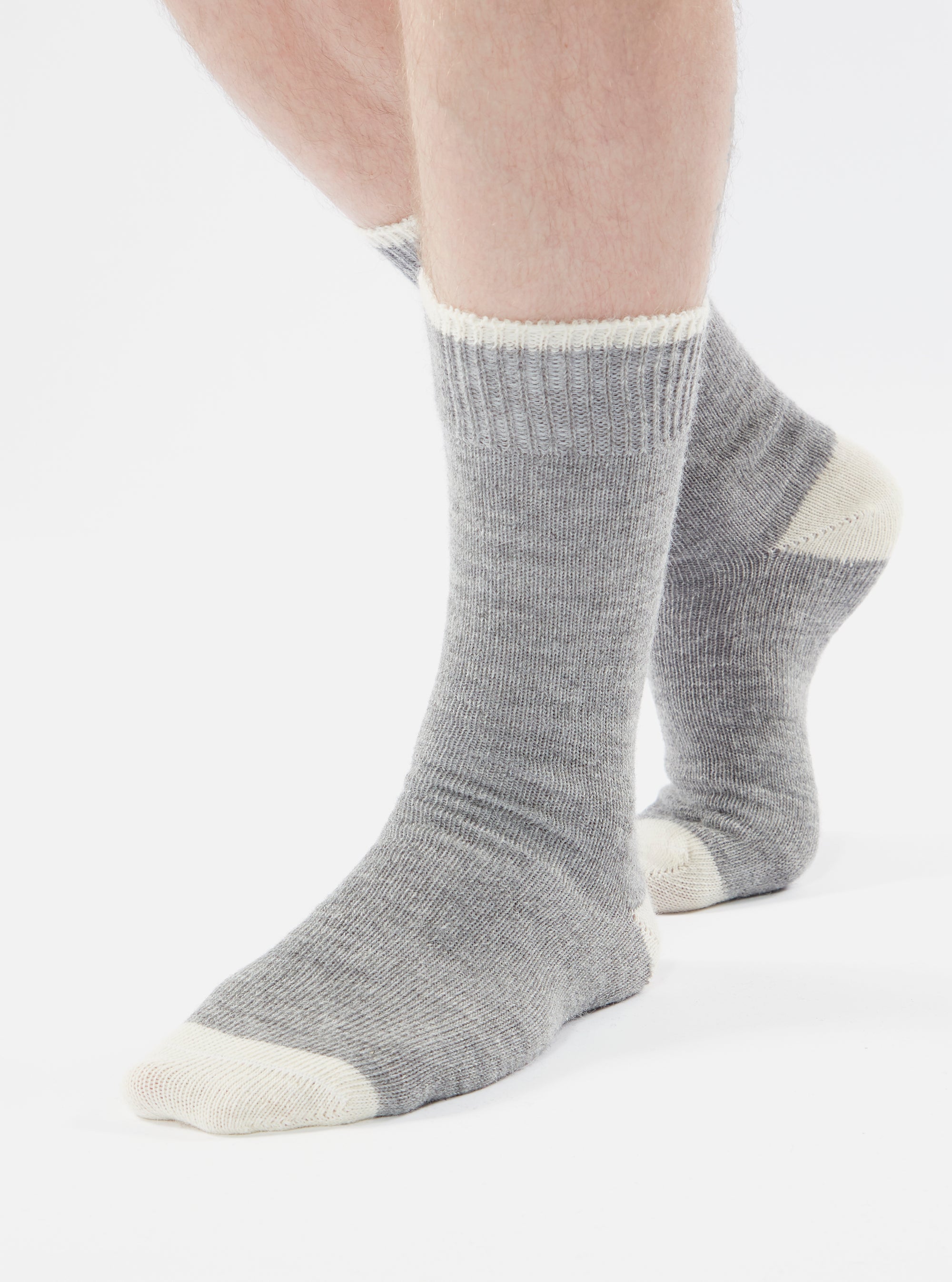 Close-up of a person wearing Grey Marl Alpaca Wool Sock on a white background. The sock is grey with a white cuff and toe.