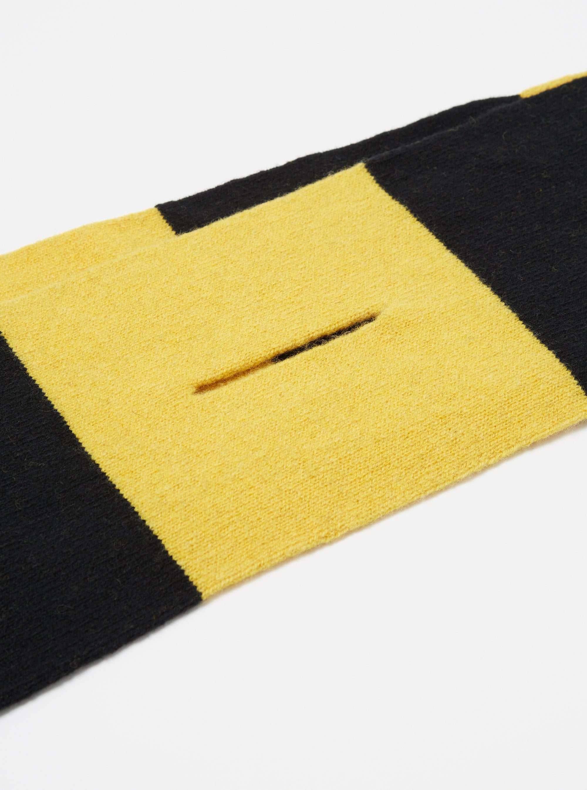 Close-up of the Black/Yellow Soft Wool Deluxe Football Scarf on a white surface. The scarf features alternating black and yellow stripes and a soft wool texture.