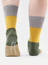 Close-up of the back of two legs wearing Grey/Gold Cotton Bold Stripe Sock on a white background. The socks have grey, gold, green and tan stripes.