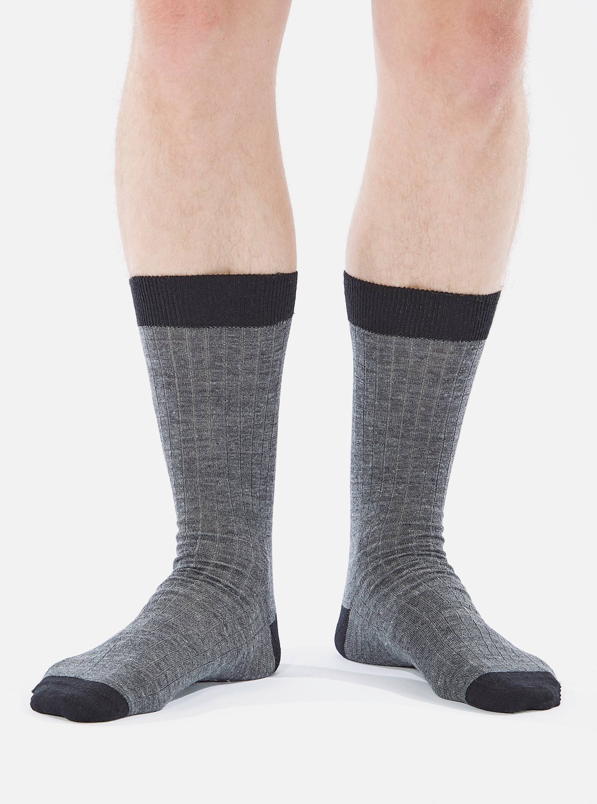 Close-up of a model wearing Grey Marl Merino Classic Sock, showcasing the ribbed texture and color contrast on a white background.