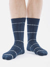 Close-up of a model wearing Navy Tie Dye Knit Slub Sock on a white background. The sock is navy with white stripes and has a knit texture.