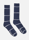 The Navy Tie Dye Knit Slub Sock, a ribbed knit sock in navy with white tie dye stripes, on a white background.