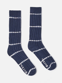 The Navy Tie Dye Knit Slub Sock, a ribbed knit sock in navy with white tie dye stripes, on a white background.